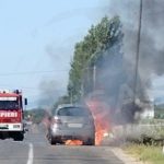 foto masina cuprinsa de flacari nor dens de fum langas trecerea la nivel cu calea ferata